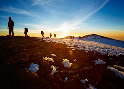 Group of mountain climbers at sunrise